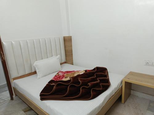 a bed with a brown blanket on top of it at Hotel Leo in New Delhi