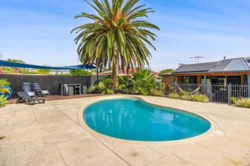 a swimming pool in the backyard of a house at Relaxed Coastal Living with Poolside Bliss - Mullaloo in Perth
