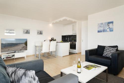 a living room with a couch and a table at Panorama Meerblick II in Staberdorf