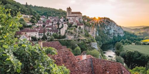 a village on a hill with a castle on it at Le Dolmen, charme sport et détente in Saint-Chels