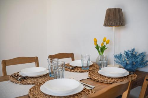 a table with plates and glasses and flowers on it at Sztormowa 7 in Jastarnia