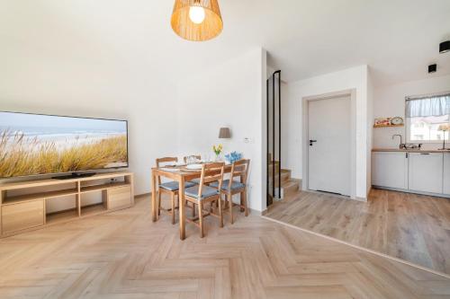 a dining room with a table and a large screen tv at Sztormowa 7 in Jastarnia
