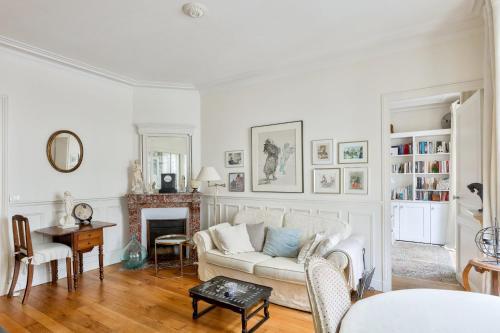 un salon avec un canapé blanc et une table dans l'établissement Stunning Parisian 1BR Flat near Sacré-Cœur, à Paris