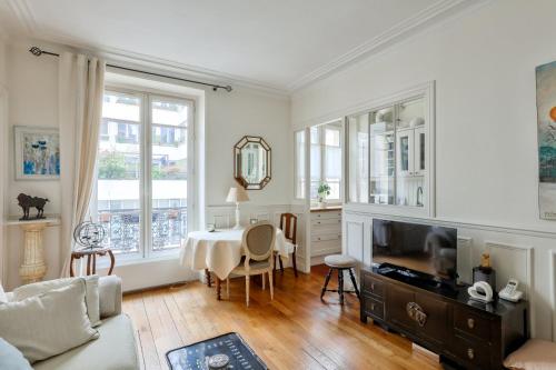 un salon avec une table et un canapé dans l'établissement Stunning Parisian 1BR Flat near Sacré-Cœur, à Paris