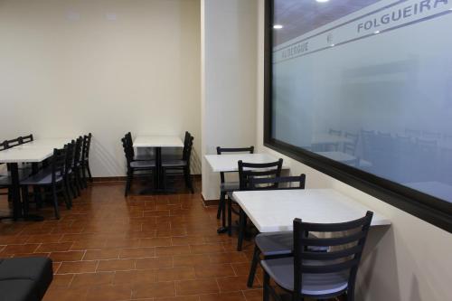 un comedor con mesas y sillas y una pantalla de proyección en Albergue Folgueira, en Portomarín
