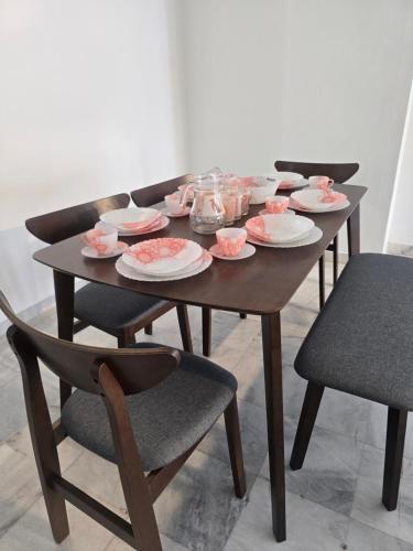 a wooden table with plates and dishes on it at PJ Homestay in Bayan Lepas
