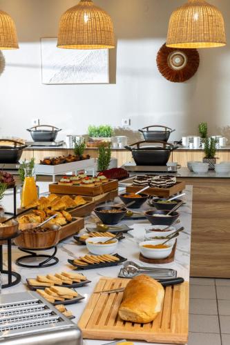 een buffet met brood en ander eten op een tafel bij Petra Nera Skiathos, Philian Hotels & Resorts in Agia Paraskevi
