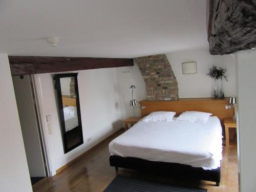 um quarto com uma cama branca e um espelho em Chambres D'Hotes Rekko em Maastricht