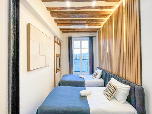 deux lits dans une chambre avec une fenêtre dans l'établissement Urban Flat 67 - Spacious Flat in Central Paris, à Paris
