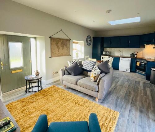 a living room with a couch and a kitchen at Stone Barn Cottage In Galway Countryside in Athenry