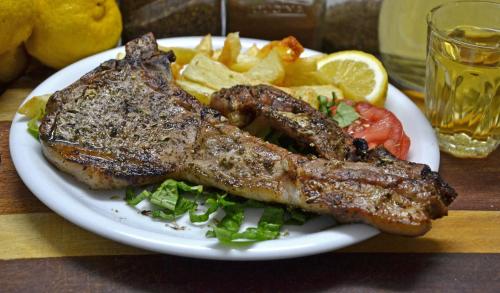 a plate of food with meat and french fries at Orthi Ammos in Frangokastello