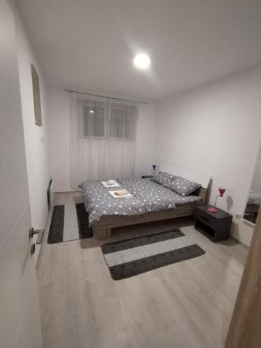 a small bedroom with a bed and a window at Apartman Una in Soko Banja