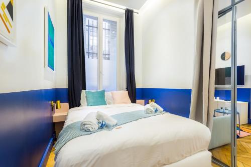 - une chambre avec un lit aux murs bleus et blancs dans l'établissement Moderne apartment - 1BR 4P - AC - Champs-Élysées, à Paris