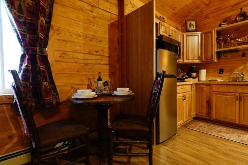 a kitchen with a small table and a refrigerator at Moose-AKa's Cabins in Healy