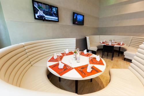 a dining room with a table and chairs and a tv at Novotel Tunis in Tunis