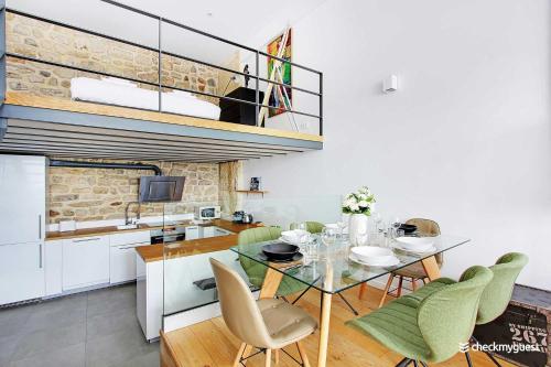 une cuisine et une salle à manger avec une table et des chaises en verre dans l'établissement Elegant apartment - 1BR-6P- Grands Boulevards, à Paris