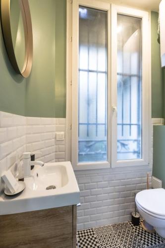 une salle de bain avec un lavabo et des toilettes et une fenêtre dans l'établissement Cosy and peaceful studio - 2P - Paris Center, à Paris