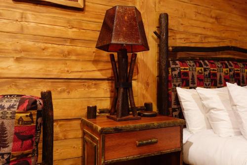 a lamp on a night stand next to a bed at Moose-AKa's Cabins in Healy