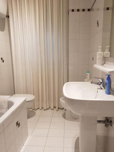 a white bathroom with a sink and a toilet at la casa al mare in Pescara