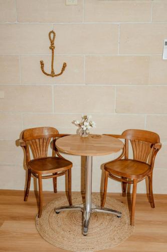 a wooden table with two chairs and a table with flowers at Portside Motel in Port Campbell