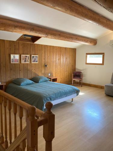 - une chambre avec un lit et un mur en bois dans l'établissement Mazet des Cèdres au pied de la colline, à Lagnes