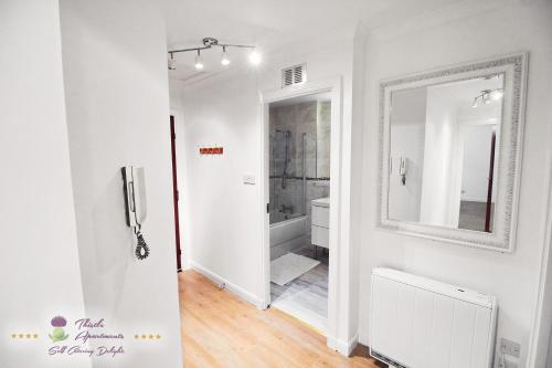 a white room with a mirror and a bathroom at Thistle Apartments - Bon-Accord Apartment in Aberdeen