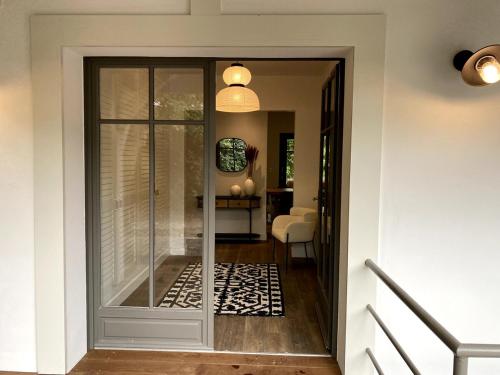 une porte en verre donnant sur un couloir avec une chambre dans l'établissement Villa Romaline - Plage Pereire - Piscine chauffée, à Arcachon