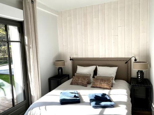 une chambre avec un lit avec deux oreillers dessus dans l'établissement Villa Romaline - Plage Pereire - Piscine chauffée, à Arcachon