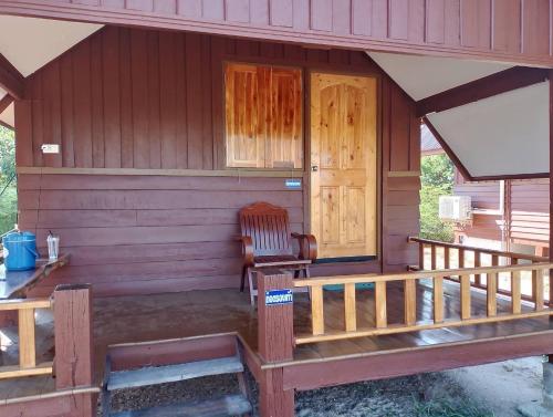 a porch of a house with a chair and a door at หาดกำนันแคมป์ปิ้ง&ซีฟู๊ด in Ban Laem Sui