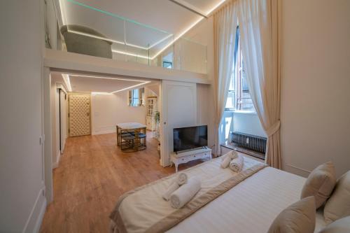 a bedroom with a large white bed and a television at Heart of Rome - Pantheon View in Rome