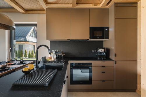 a kitchen with a black counter top and a sink at Osada Maruszyna in Szaflary