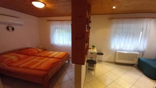 a bedroom with a bed and a blue couch at Fenyves Villa in Balatonfenyves