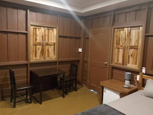 a room with a table and chairs and a bed at หาดกำนันแคมป์ปิ้ง&ซีฟู๊ด in Ban Laem Sui