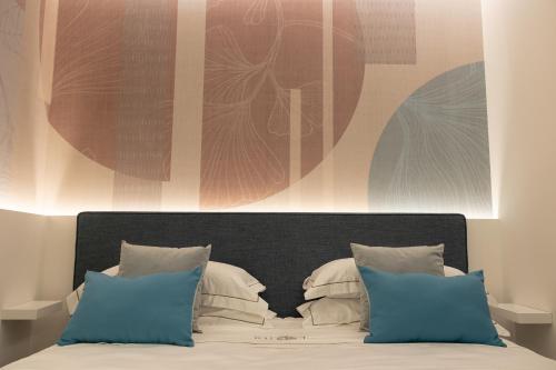 a bedroom with a bed with blue pillows and a painting at Radici Tropea in Tropea