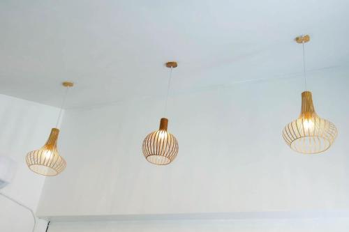 a group of three lights hanging from a ceiling at The Nanda Beach Resort in Sikao