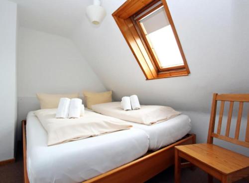 1 Schlafzimmer mit 2 Betten, einem Spiegel und einem Stuhl in der Unterkunft Haus Atlantis "Holzwohnung 3" in Hörnum
