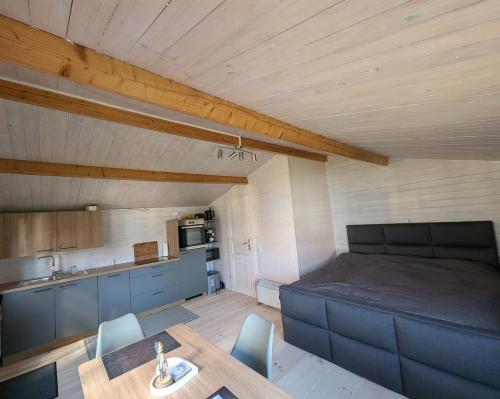 a room with a bed and a table and a kitchen at Ferienhaus am See Wutzsee mit direktem Seezugang in Lindow