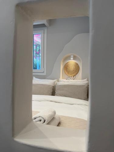 a mirror reflection of a bed in a bedroom at Fratelli Family Rooms in Tinos Town