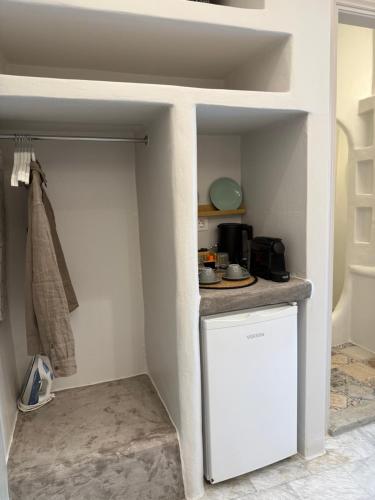 a small kitchen with a counter in a room at Fratelli Family Rooms in Tinos Town