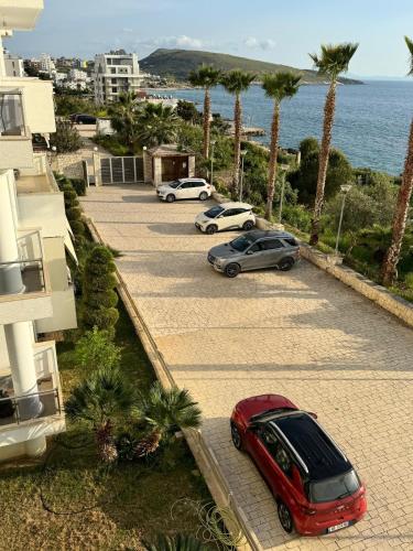 Deux voitures garées sur un parking près de l'océan dans l'établissement Jonian Waves, à Saranda