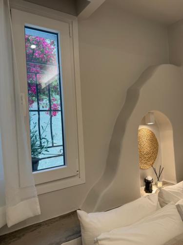 a bedroom with a window and a bed and a lamp at Fratelli Family Rooms in Tinos Town