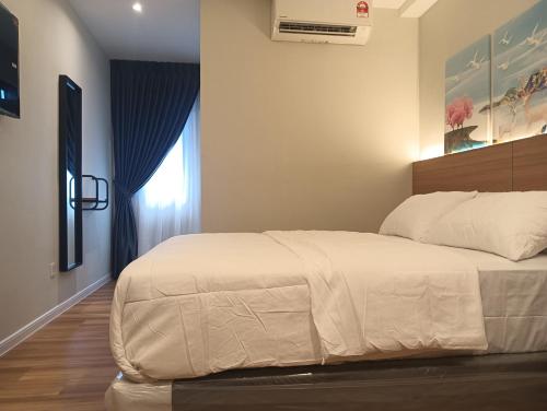 a bedroom with a large white bed in a room at Karasky Hotel in Simpang Ampat