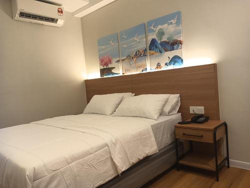a bedroom with a bed and a nightstand next to a bed sidx sidx sidx at Karasky Hotel in Simpang Ampat