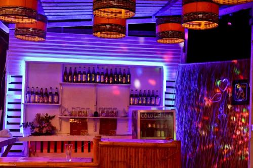 a bar with bottles of alcohol on the wall at The Nanda Beach Resort in Sikao