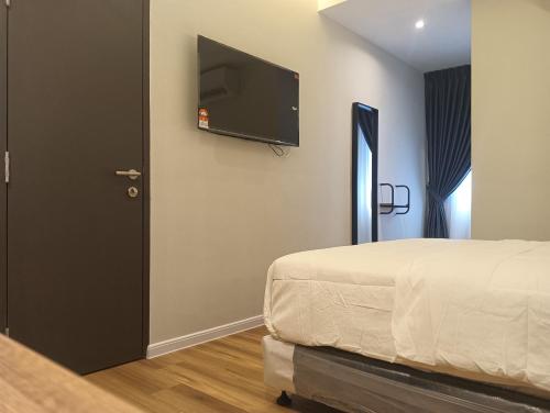 a bedroom with a bed and a flat screen tv at Karasky Hotel in Simpang Ampat