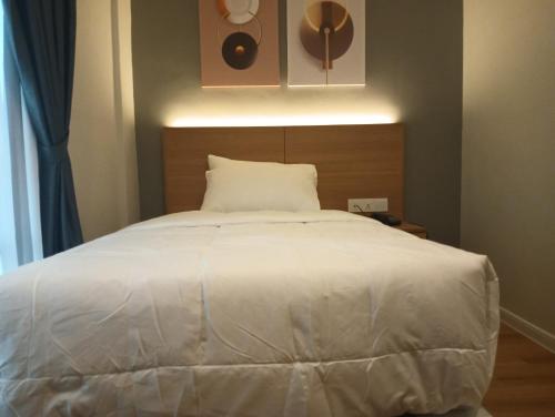 a bedroom with a large white bed with a headboard at Karasky Hotel in Simpang Ampat