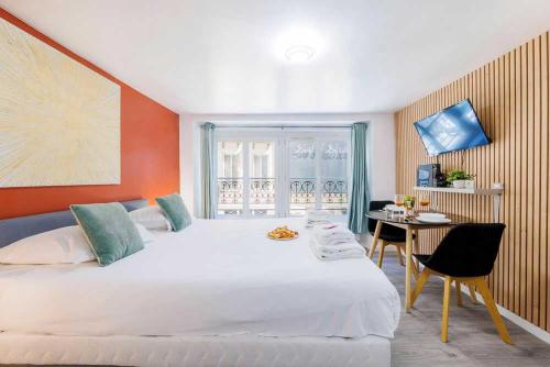 une chambre avec un grand lit blanc et un bureau dans l'établissement Cosy studio for 2 people - Jardin du Luxembourg, à Paris