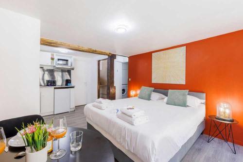 une chambre avec un grand lit avec un mur orange dans l'établissement Cosy studio for 2 people - Jardin du Luxembourg, à Paris