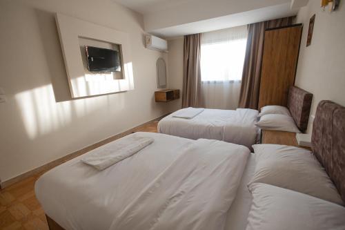 a hotel room with two beds and a tv at The View Pyramids Gold Two in Cairo