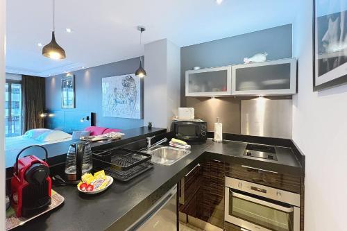 une cuisine avec un comptoir noir dans une pièce dans l'établissement Cannes Gray d'Albion studio quiet terrace city center near beach, à Cannes